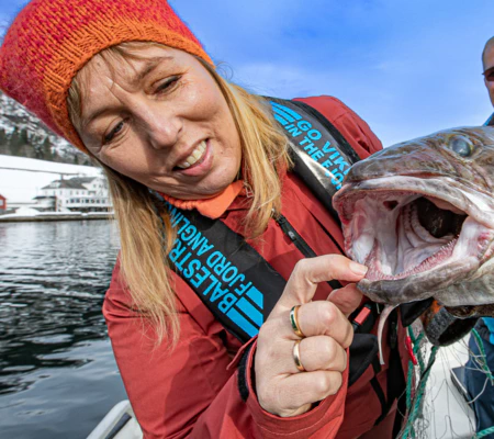 nyskerrig dame, skejjer munnen på fisk ig jakke i fine farger matauk i sognefjorden, brosme i fjærlandsfjorden